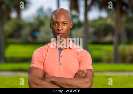 Porträt einer hübscher junger Geschäftsmann im Freien in einem rosa Poloshirt posing Stockfoto