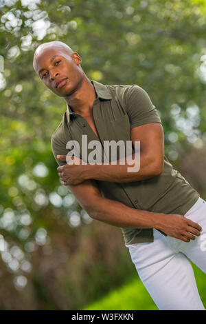 Portrait einer jungen afrikanischen amerikanischen Mann in ein harter Kerl pose mit Arm gekreuzt Stockfoto