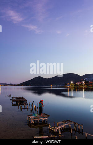 Leute angeln auf eine beschädigte Pier in Conceicao Lagune bei Sonnenuntergang. Florianopolis, Santa Catarina, Brasilien. Stockfoto