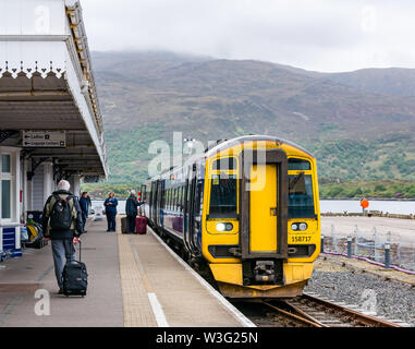 ScotRail tran an Plattform, Kyle von Lochalsh entfernt, und die Fluggäste mit Koffern, Schottland, Großbritannien Stockfoto