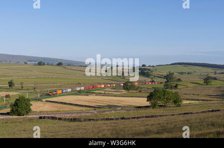 Diesellokomotive der DB-Frachtklasse 66 auf der Westküsten-Hauptstrecke bei Shap in Cumbria mit intermodalem Containerzug Stockfoto