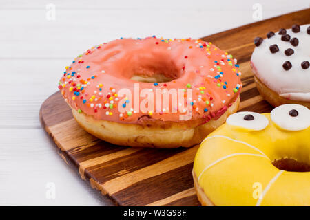 Frisch gebackene Donuts auf Holzhintergrund. Stockfoto