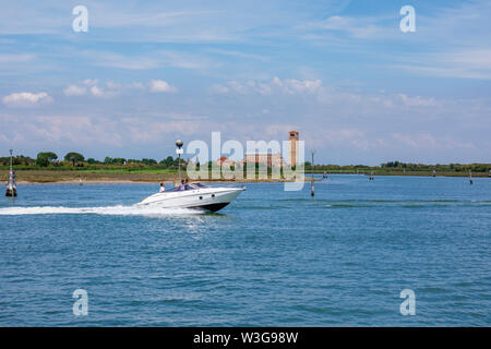 Weiß Schnellboot Beschleunigung von Torcello, einer kleinen Insel in der Lagune von Venedig, Italien: Blick auf die Kathedrale Santa Maria Assunta, Santa Fosca und Campanile Stockfoto