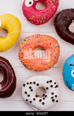 Sortiment von Donuts auf Holzhintergrund. Stockfoto