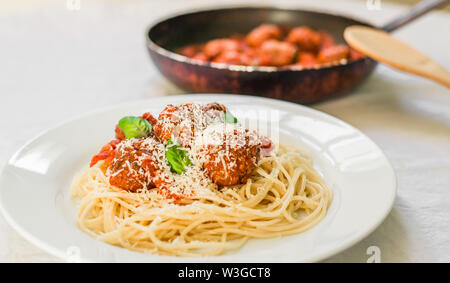 Spaghetti Nudeln mit Hackfleischbällchen in Tomatensauce, Käse über sie fallen Stockfoto