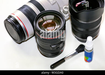 Objektive auf Anzeige von Canon 100-400mm Telezoom objektiv, Tamron 15-30 mm Ultra Wide Angle Lens Cleaning Kit auf weißem Hintergrund Stockfoto