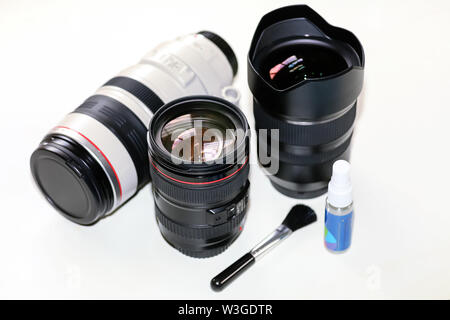 Objektive auf Anzeige von Canon 100-400mm Telezoom objektiv, Tamron 15-30 mm Ultra Wide Angle Lens Cleaning Kit auf weißem Hintergrund Stockfoto