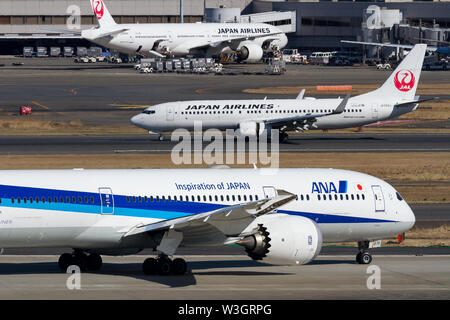 An All Nippon Airways )ANA) Boeing 787 Dreamliner Taxis fahren am Haneda Airport, Tokyo, Japan, an einer Japan Airlines (JAL)Boeing 737-846 vorbei. Stockfoto