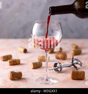 Rotwein wird in ein Glas gegossen. Das Konzept der Weinbereitung. Close-up. Platz. Stockfoto