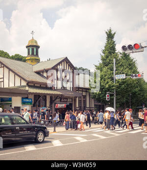 Menschen und Menschenmassen außerhalb des geschäftigen Harajuku Stationsgebäudes, einem Bahnhof in Harajuku, Tokio, Japan. Stockfoto