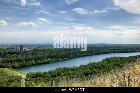 Wunderschöne natürliche Landschaft des Flusses in einem grünen Wald unter einem klaren blauen Himmel mit einigen weissen Wolken am Horizont Stockfoto