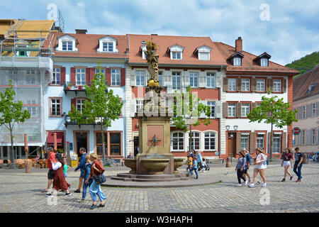 Platz namens "Kornmarkt" in der Altstadt mit Brunnen mit Goldene Madonna Statue und Leute, an einem sonnigen Tag in Heidelberg, Deutschland Stockfoto