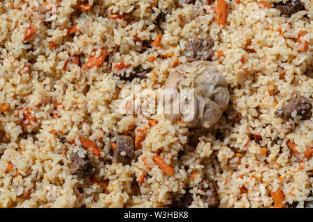Traditionelle Östliche kulinarischen Gericht - Pilav. Zutaten: Reis mit Fleisch, Fett und Gemüse (Karotte, Knoblauch), Gewürze - beliebtes Rezept. Schließen - Stockfoto