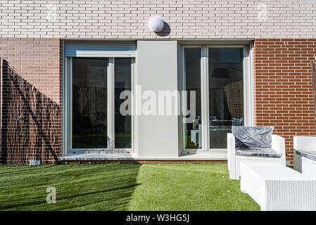 Garten von modernen Backsteingebäude Reihenhäuser in minimalistischer Form. Außenaufnahme an einem sonnigen Tag Stockfoto