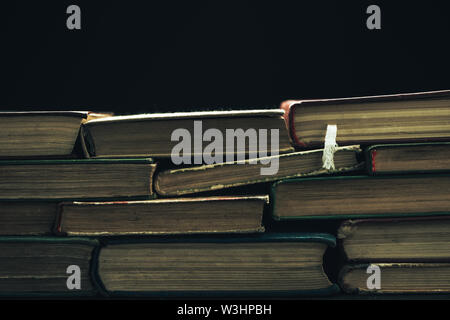 Schließen Sie herauf alte Bücher auf einem schwarzen Hintergrund. Stockfoto