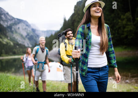 Lächelnd Freunde gehen mit Rucksäcken. Abenteuer, Reisen, Tourismus, Wandern und Menschen Konzept. Stockfoto