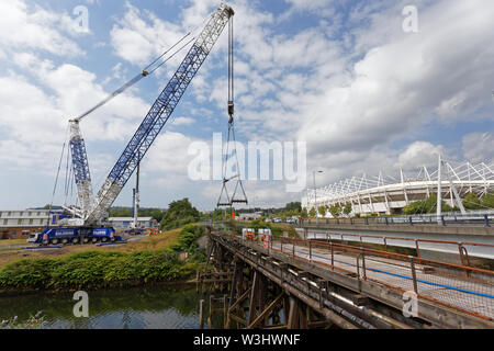 Im Bild: Ein Kran bereitet die Klappbrücke über den Fluss Tawe in der Morfa Bereich von Swansea, Südwales. Sonntag, den 14. Juli 2019: Re: 110 Jahre ol Stockfoto