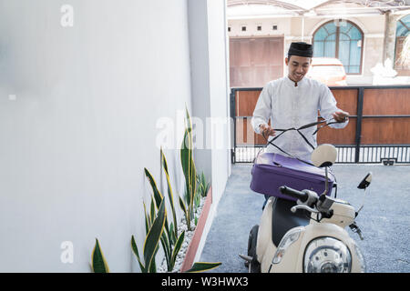 Asiatische muslimischer männlicher Reisen für Eid Mubarak lebaran durch die motorradhalterung. mudik Balik kampung Konzept per Motorrad Stockfoto