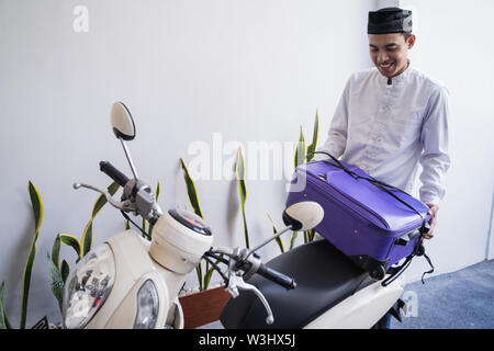 Asiatische muslimischer männlicher Reisen für Eid Mubarak lebaran durch die motorradhalterung. mudik Balik kampung Konzept per Motorrad Stockfoto