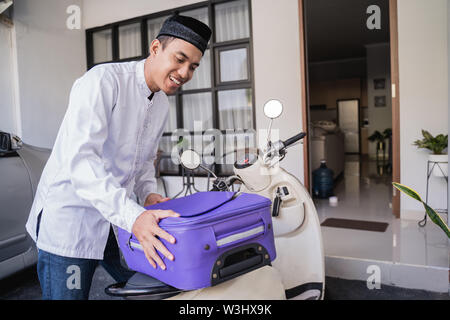 Asiatische muslimischer männlicher Reisen für Eid Mubarak lebaran durch die motorradhalterung. mudik Balik kampung Konzept per Motorrad Stockfoto