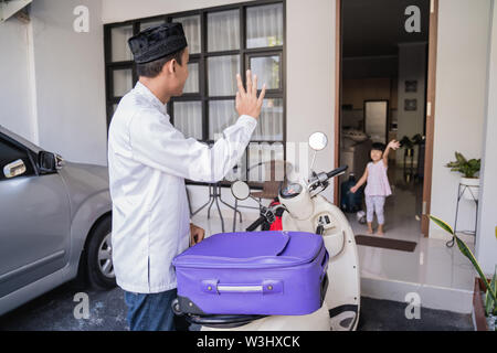 Asiatische muslimischer männlicher Reisen für Eid Mubarak lebaran durch die motorradhalterung. mudik Balik kampung Konzept per Motorrad Stockfoto