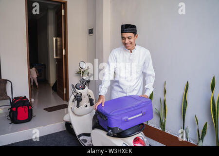 Asiatische muslimischer männlicher Reisen für Eid Mubarak lebaran durch die motorradhalterung. mudik Balik kampung Konzept per Motorrad Stockfoto