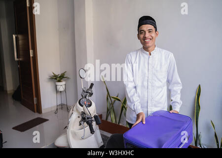 Asiatische muslimischer männlicher Reisen für Eid Mubarak lebaran durch die motorradhalterung. mudik Balik kampung Konzept per Motorrad Stockfoto