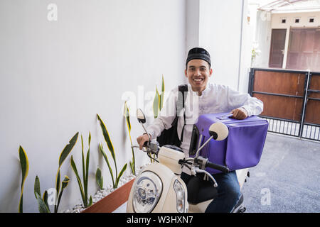 Asiatische muslimischer männlicher Reisen für Eid Mubarak lebaran durch die motorradhalterung. mudik Balik kampung Konzept per Motorrad Stockfoto