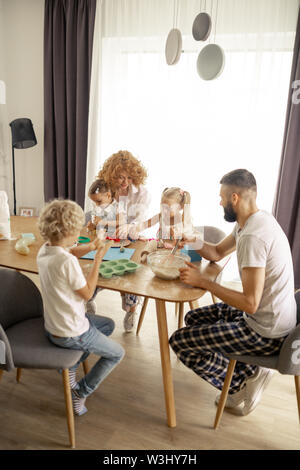 Große familie. Angenehme united Familie zusammen am Tisch sitzen beim Kochen Stockfoto