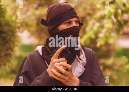 Einbrecher in der Maske Holding und die Pistole outdoor Nachladen Stockfoto