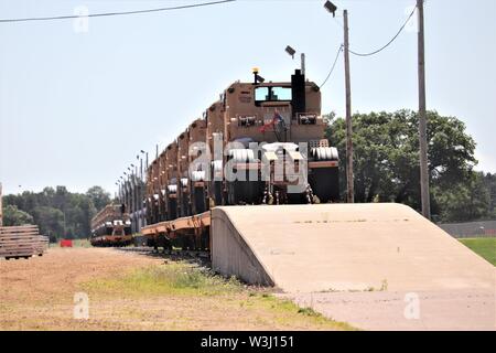 Militärische Fahrzeuge und Ausrüstungsgegenstände von der 1158th Transportation Company der Wisconsin National Guard sind auf triebwagen Juli 10, 2019, am Fort McCoy, Wis. Die Unternehmen, die Ausrüstung ist in Fort Hood, Texas, geladen, ein Teil einer großen Übung später im Jahr zu sein. Die Schiene wird geladen und die damit verbundenen Arbeiten wurde von der 1158th Soldaten und Mitarbeiter mit der Festung McCoy Logistics Readiness Center Transport Division abgeschlossen. (U.S. Armee Foto von Scott T. Sturkol, Public Affairs Office, Fort McCoy, Wis.) Stockfoto