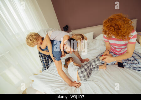 Zeit für Spaß. Freuen glückliche Kinder Spaß beim Spielen mit ihren Eltern Stockfoto