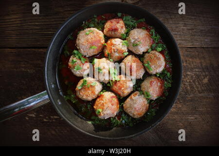 Fleischbällchen in süß-saurer Tomatensauce auf rustikalen Tisch. Ansicht von oben Stockfoto