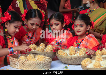 Junge Tänzer bieten die Körbe mit traditionellen süßen 'moa' aus puffreis bei 'Nabanna Utsab', die bengalischen Harvest Festival. Dhaka, Bangladesch Stockfoto