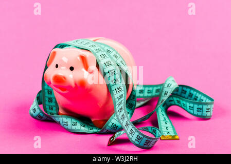 Wirtschaft und Finanzen. Pig trap. Haushalt Krise. Planung Budget. Business problem. Begrenzt oder eingeschränkt. Sparschwein und Maßband. Budget limit Konzept. Kredit Darlehen schulden. Financial Consulting. Stockfoto