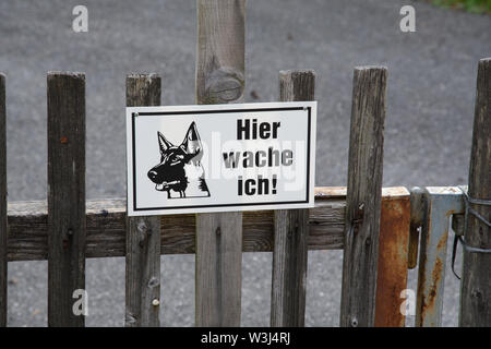 HALLSTATT, Österreich - 23 AUG 2018: ein Zeichen auf den Zaun für unvorsichtige Touristen mit einer Erläuterung, dass das Haus von einem Wächter bewacht wird Stockfoto