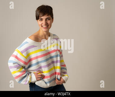 Portrait von glücklich und überrascht die jungen kaukasischen Frauen lachen und Spaß in grün gestreiften Pullover in neutralen Hintergrund isoliert. Menschen, Stockfoto