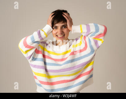 Portrait von glücklichen jungen kaukasischen Frauen lachen und Hände auf den Kopf in der Überraschung tragen grün gestreiften Pullover in neutralen Hintergrund isoliert. Pe Stockfoto