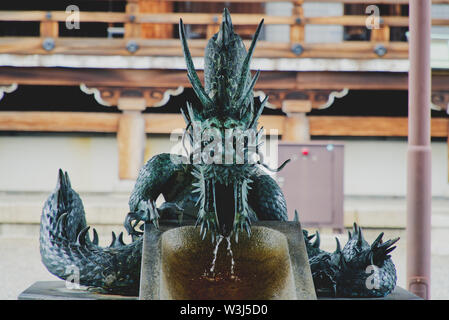 Bild von einem Drachen Brunnen an einem japanischen Tempel, Brunnen für die Reinigung Ritual Stockfoto