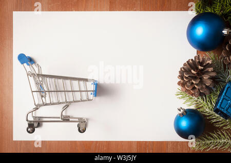 Weihnachten Blau und Grün Dekorationen auf Holztisch und einem großen weißen Karte mit Warenkorb auf es als Kopie Raum Stockfoto