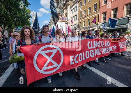 London, Großbritannien. 15. Juli 2019. Das banner an der Vorderseite des Aussterbens Rebellion März aus der Royal Courts of Justice, um Ihre Website für die nächsten drei Tage bei Waterloo Millennium Grün. Sowie die Demonstranten mit Transparenten, es gab ein riesiges rosa Dodo, und an der Rückseite der Prozession der Yacht Polly Higgins, für die Umwelt Rechtsanwalt, der seit Jahren für ein Gesetz gegen Umweltzerstörung kämpfte und starb im April dieses Jahres benannt. Credit: Peter Marschall/Alamy leben Nachrichten Stockfoto