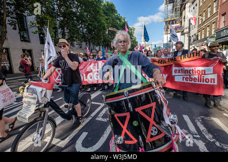 London, Großbritannien. 15. Juli 2019. Schlagzeuger an der Vorderseite des Aussterbens Rebellion März aus der Royal Courts of Justice, um Ihre Website für die nächsten drei Tage bei Waterloo Millennium Grün. Sowie die Demonstranten mit Transparenten, es gab ein riesiges rosa Dodo, und an der Rückseite der Prozession der Yacht Polly Higgins, für die Umwelt Rechtsanwalt, der seit Jahren für ein Gesetz gegen Umweltzerstörung kämpfte und starb im April dieses Jahres benannt. Credit: Peter Marschall/Alamy leben Nachrichten Stockfoto