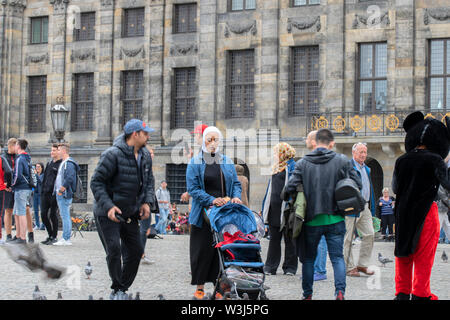 Touristen füttern Tauben in Amsterdam Die Niederlande 2019 Stockfoto