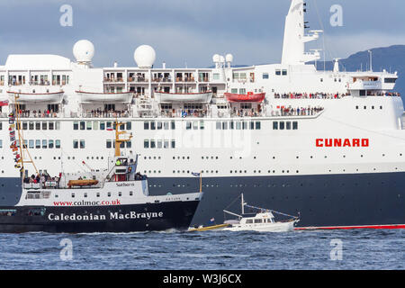 QE2 segelt den Firth of Clyde während des Finales hinauf Besuch in Schottland neben der kaledonischen MacBrayne Fähre Saturn in Großbritannien Stockfoto