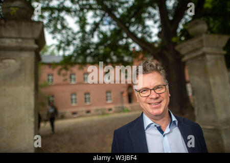 16 Juli 2019, Sachsen-Anhalt, Wittenmoor: Olaf Stehwien, Geschäftsführer der Konditorei Stehwien steht in der Zufahrtsstraße zum Gutshaus Wittenmoor. Der Unternehmer plant, seinen Firmensitz von Tangermünde in die Immobilien in Wittenmoor bewegen. Der Landkreis Stendal unterstützt das Projekt mit Mitteln aus dem Pilotprojekt "Land (auf) Schwung" des Bundesministeriums für Ernährung und Landwirtschaft. Das Geld wird verwendet, um teilweise die Immobilie renovieren. Eine Art von "chocolate-Schloss" mit Räumen für Veranstaltungen rund um Schokolade geplant. Foto: Klaus-Dietmar Gabbert/dpa-Zentralbild/ZB Stockfoto