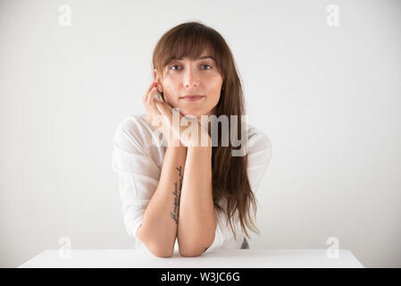 Porträt einer schöne Brünette kaukasische Frau tragen weiße gegen einen weißen Hintergrund Stockfoto