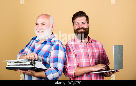 Alte generation. bärtigen Männern. Vintage Schreibmaschine. Vater und Sohn. Familie generation. retro Schreibmaschine laptop vs. Neue Technologie. Technologie Schlacht. Modernes Leben. Jugend vs Alter. business Ansatz. Stockfoto