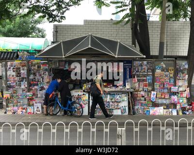 (190716) - Peking, 16. Juli 2019 (Xinhua) - Foto mit einem Handy aufgenommen zeigt einen Mann sie an einem Zeitungskiosk in Peking, der Hauptstadt von China, 16. Juli 2019. (Xinhua / Wang Junlu) Stockfoto