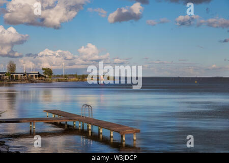 Steg mit einer schönen Aussicht auf das Markermeer in der Dämmerung in den Niederlanden Stockfoto