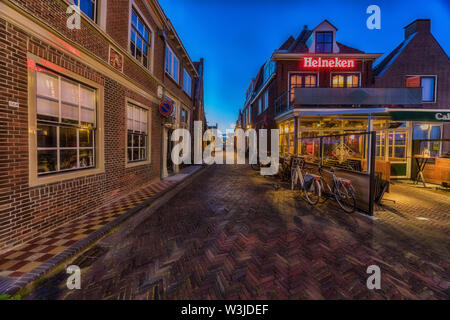 Enkhuizen, Niederlande - 04 Mai, 2019: Alte Straße in Enkhuizen am IJsselmeer in den Niederlanden während der Dämmerung. Stockfoto